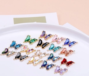 Primer plano de dijes de mariposa de cristal coloridos con bordes dorados para joyas