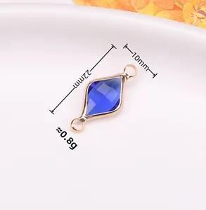 Dettaglio macro del ciondolo a rombo placcato oro 22x10mm con cristallo blu e due anelli