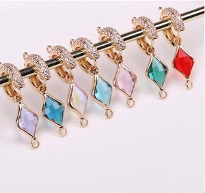 Macro detail of faceted crystal diamond pendants in multiple colors with gold plating