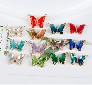 Detailed macro view of 14K gold butterfly pendants with colorful crystals for DIY jewelry