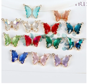 Detailed macro view of multi-colored crystal butterfly charms with gold plated edging