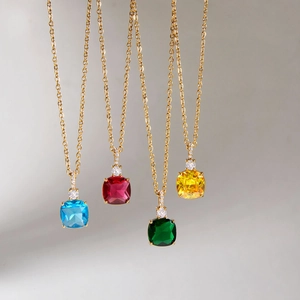 Dettaglio di quattro collane in oro 18k con ciondoli di pietre preziose colorate