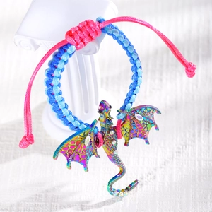 Close-up of rainbow dragon charm on pink and blue woven bracelet with rhinestones