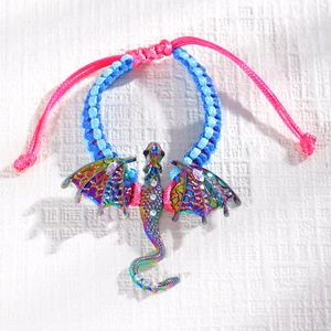 Detail van een gevlochten armband met een kleurrijke iriserende draak hanger en kristallen