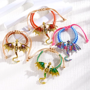 Detail of hand-woven dragon bracelets with colorful enamel wings and adjustable cords
