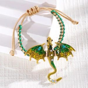 Detail of a woven dragon bracelet with gold metal base and colorful enamel wings