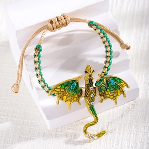 Detail van handgeweven drakenarmband met groene emaille vleugels en glimmende stras