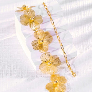 Detail van een gouden bodychain met opengewerkte bloemen en een stevige karabijnsluiting