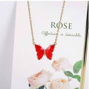 Detail of red crystal butterfly pendant with zircon on a 14K gold filled fine chain