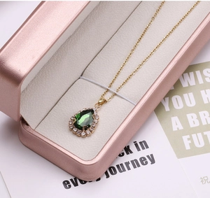 Macro di pendente a goccia dorato con cristallo verde e zirconi in confezione regalo