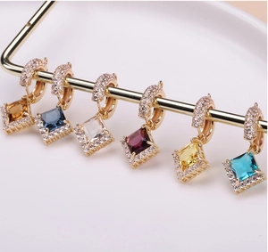 Macro detail of multi-colored square crystal pendants with gold pave setting