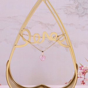 Detail of pink crystal heart pendant on gold chain with Love display stand