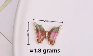 Detail van gouden vlinderhanger met inktstijl hars en afmetingen van 22mm bij 17mm