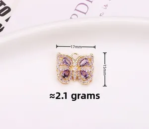 Λήψη macro χρυσού μενταγιόν πεταλούδα 15x17mm με μοβ και ροζ πέτρες ζιργκόν