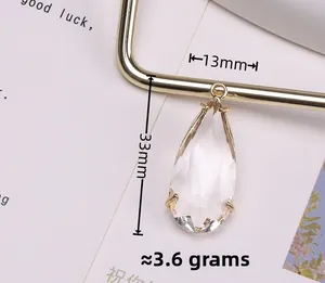 Detailed view of clear teardrop crystal pendant in 14K gold plated frame, 13x33mm size