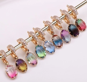 Detail of gradient faceted crystal oval pendants with gold paved diamond clasp connectors