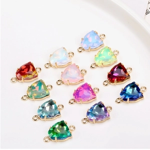 Detailed macro view of colorful faceted triangle charms with gold double loops for DIY jewelry