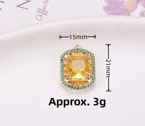 Detalle del colgante dorado rectangular con piedra amarilla y halo verde en un plato blanco