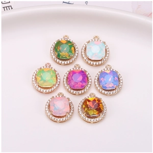 Macro detail of seven colorful square crystal pendants with zircon halo on white plate
