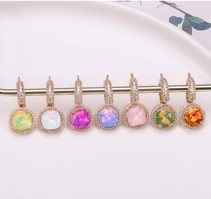 Macro detail of seven colorful square crystal pendants with halo setting in gold finish