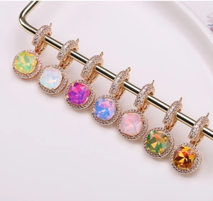 Close-up of seven colorful cushion-cut crystal pendants with zircon halos on a gold rack
