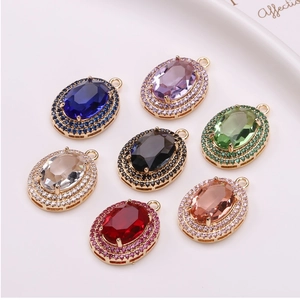 Detailed close-up of oval crystal pendants with gold metal base and micro-pave cubic zirconia