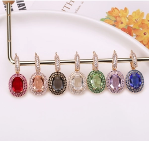 Macro shot of colorful oval crystal pendants with diamond accents on a gold-plated display