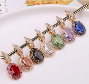Detailed macro view of seven colorful oval crystal pendants with micro-pave zircon settings