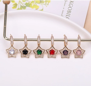 Detailed view of gold plated star pendants with colorful cubic zirconia on a display stand