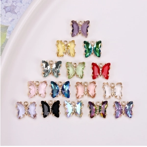 Vue détaillée de breloques papillon en cristal facetté coloré avec monture dorée fine