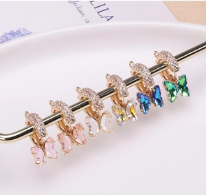 Détails de six pendentifs papillons en cristal sur des créoles dorées avec zircons pavés