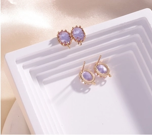Close-up of purple oval faceted crystal charms with 14K gold plated earring studs