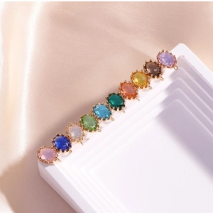 Macro view of multi-color oval crystal charms with 14K gold plated connectors for jewelry