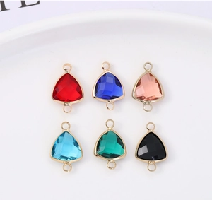 Macro detail of triangle crystal charms with gold plated edges for DIY jewelry making