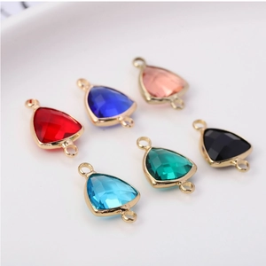 Detailed view of triangular faceted crystal charms with gold plated frames in six colors
