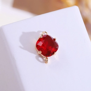 Détail du pendentif en cristal rouge taille coussin avec cadre doré 18 carats et anneaux