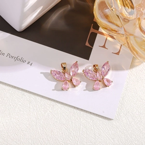 Macro detail of pink crystal butterfly pendants with gold-plated metal base and faceted wings