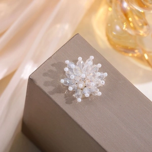 Macro shot of handcrafted white crystal and pearl flower beadwork for hair accessories