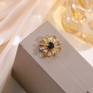 Macro detail of amber crystal flower hair clip with a vintage gold alloy base
