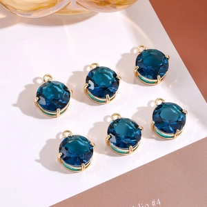 Macro-opname van zes ronde blauwe zirkoonhangers met een gouden klauwzetting voor sieraden