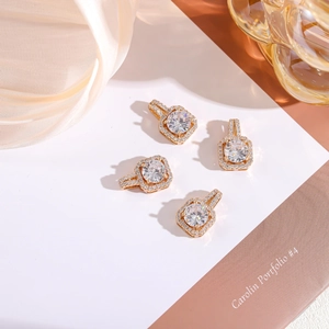 Macro view of square gold pendants with cubic zirconia inlay on silk fabric