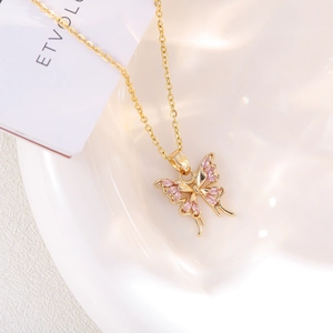 Close-up of gold butterfly pendant with pink marquise crystals on a fine link chain