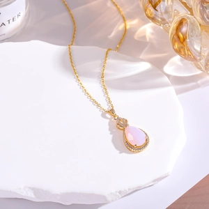 Macro detail of pink teardrop gemstone necklace with gold-plated micro-pave setting