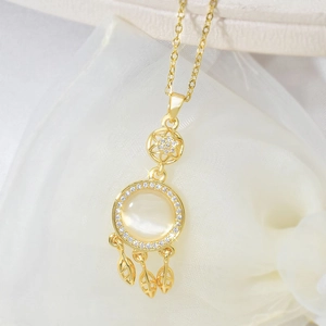 Elegant gold dreamcatcher necklace featuring a cat-eye stone and three leaf pendants