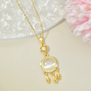 Golden dreamcatcher necklace with cat eye stone and leaf charms on a refined chain