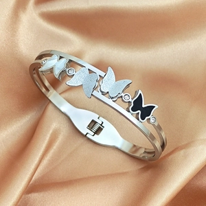 Bracelet jonc ouvert en acier avec papillons et zircon sur fond en soie couleur champagne