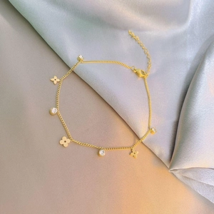 Elegantes Gold-Titan-Fußkettchen mit Blumen und weißen Zirkonia auf Silber-Satin