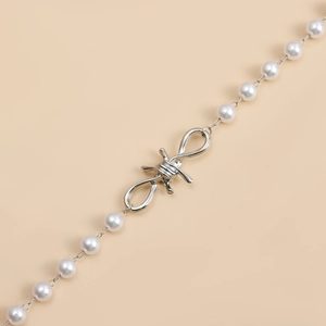 Detailaufnahme der Punk-Halskette mit weißen Perlen und silberner Kette im Dornen-Design