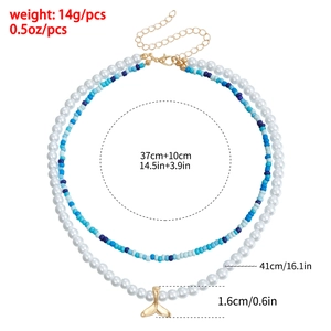 Close-up of double-layer beaded necklace with faux pearls and gold fishtail pendant