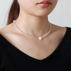 Pink glass crystal beaded necklace with a white heart pendant worn on a model